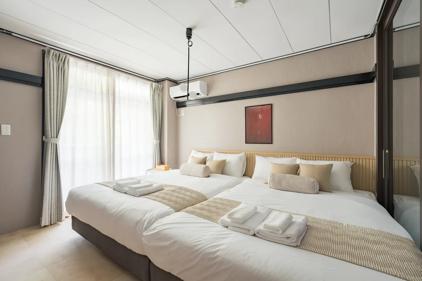 Beds set side by side in 201, curtains drawn back